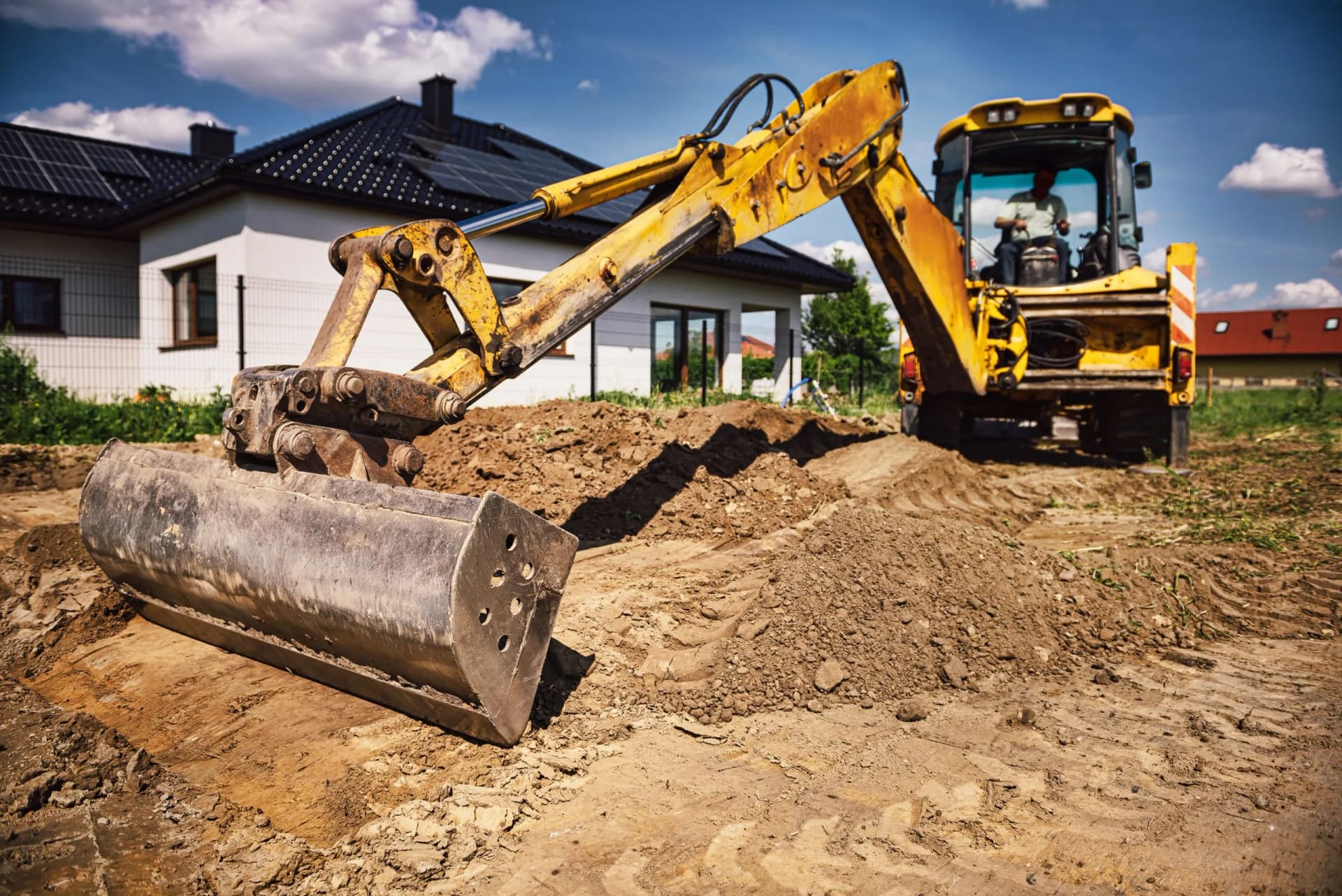Backhoe excavating and grading residential property in Anne Arundel County Maryland