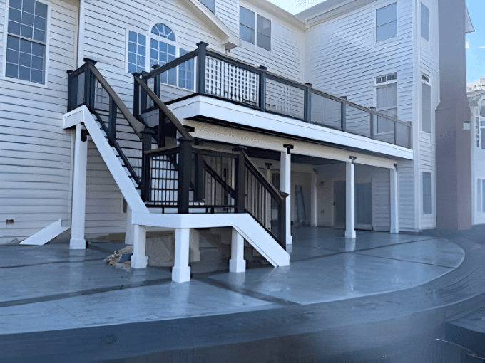 Stamped concrete patio under a custom deck by Backyard Bobby's in Anne Arundel County