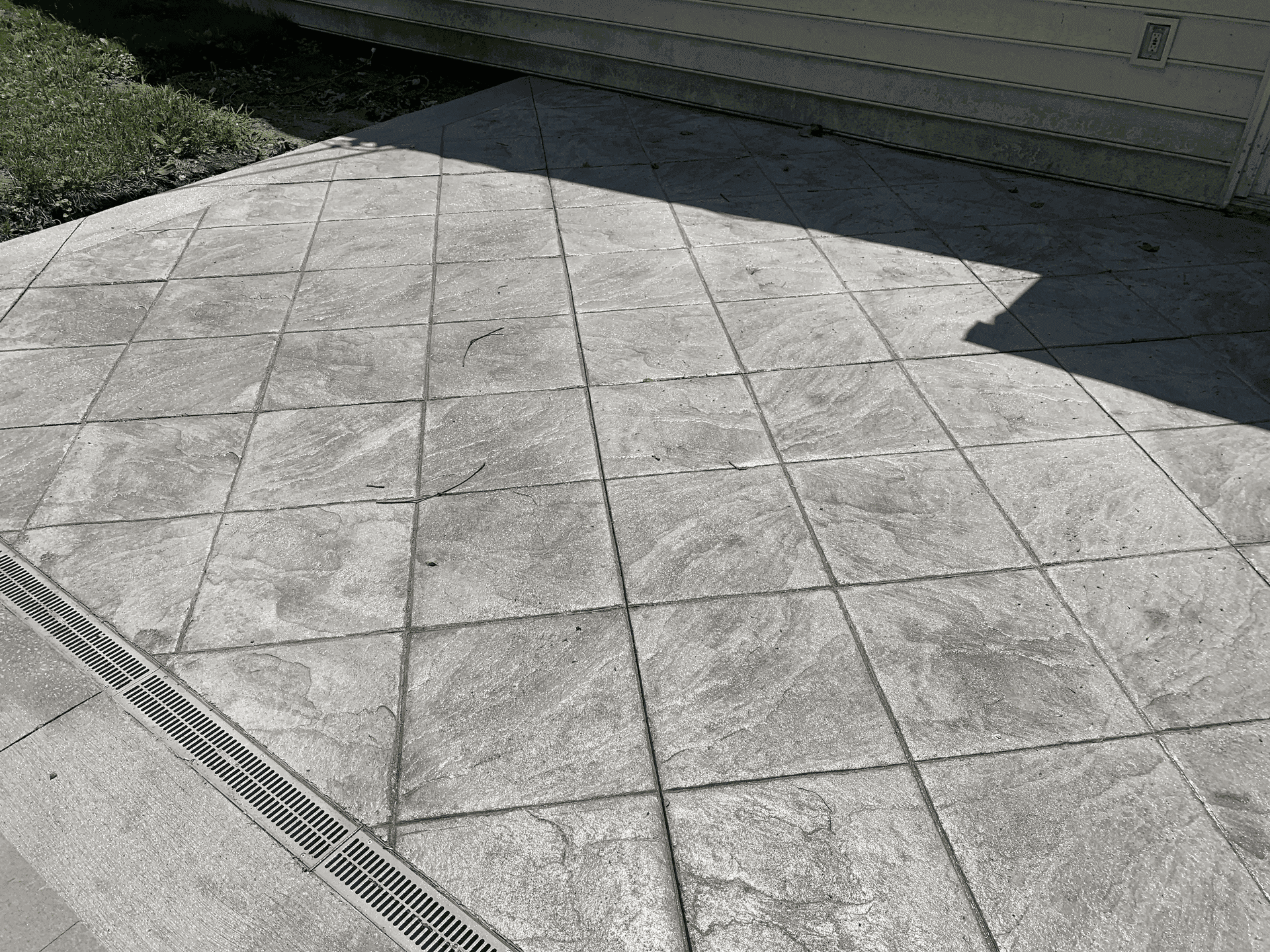 Slate-pattern concrete patio with control joints cut in a clean diamond grid