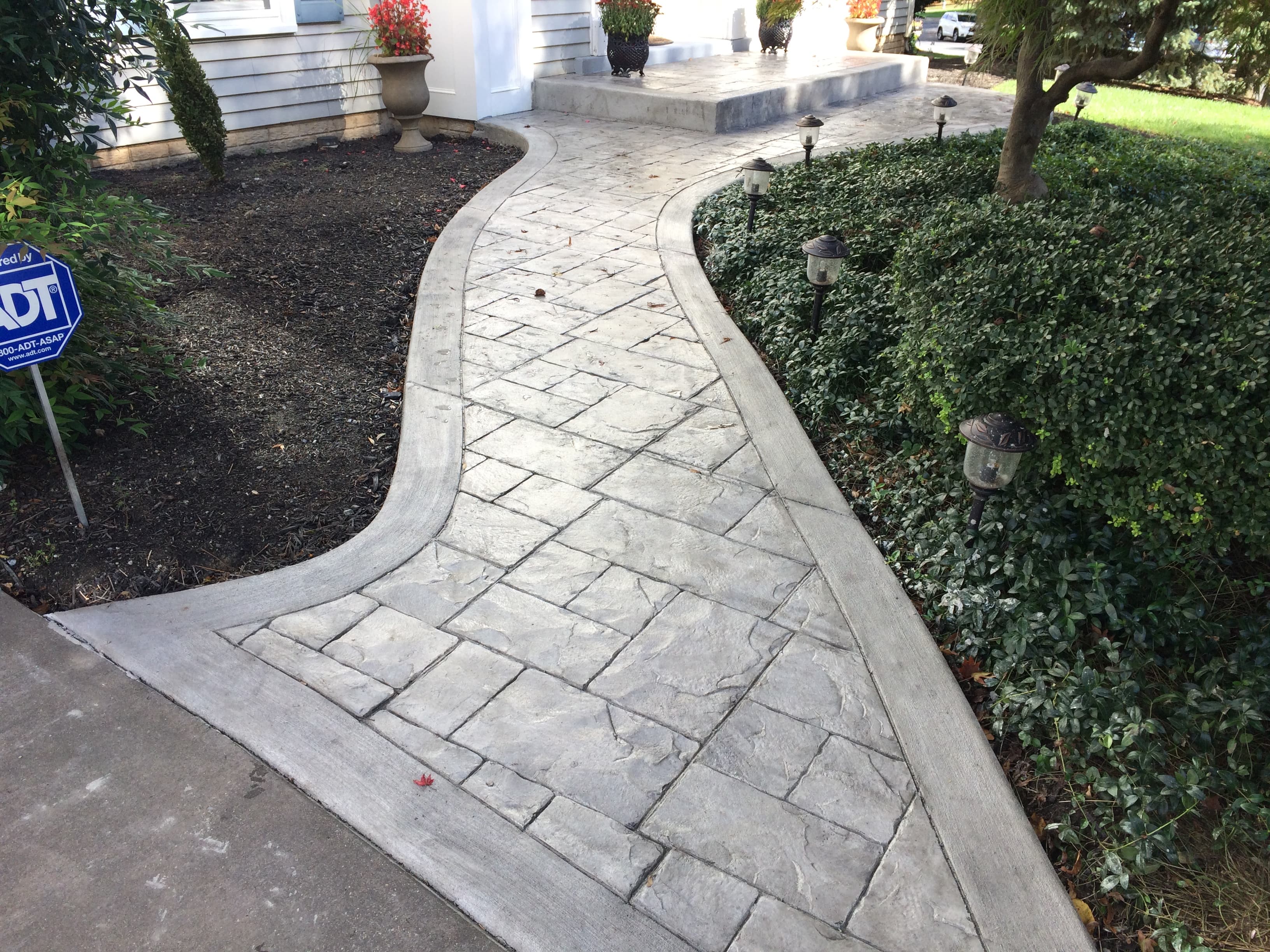 Stamped concrete walkway with ashlar slate pattern and landscaping